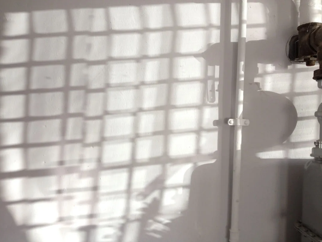 Licht fällt durch ein Gitterfenster